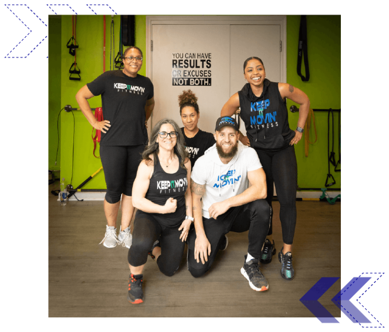 keep it movin fitness community photo four women pose with lead trainer Dante Puchala wearing the studio's log on shirts