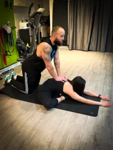 Lead Trainer Dante Puchala assists a client with hands-on stretching and muscle decompression.